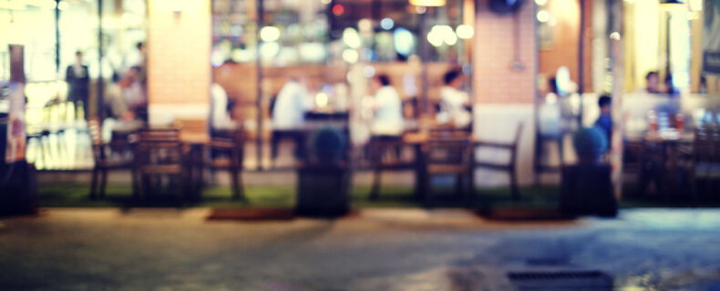 a blurry restaurant scene with people sitting in chairs and tables and eating small business